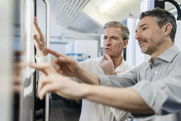 Businessmen in factory, having a meeting, discussing plans - DIGF09746