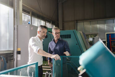 Businessmen in factory, having a meeting, discussing solutions - DIGF09772