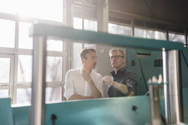 Businessmen in factory, having a meeting, discussing solutions - DIGF09774