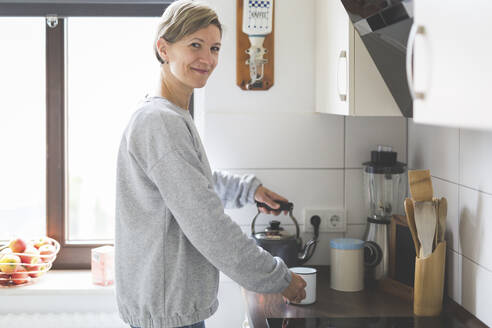 Ältere Frau bereitet Tee in der Küche zu - ASCF01240