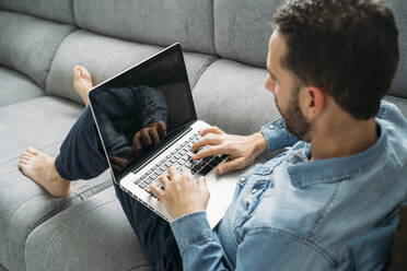 Geschäftsmann mit Laptop bei der Arbeit von zu Hause aus während des Ausbruchs der Coronavirus-Pandemie, Almeria, Spanien, Europa - MPPF00865