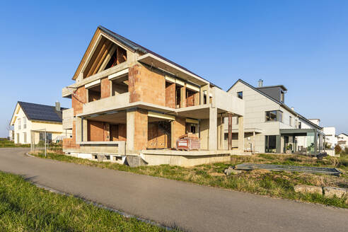 Deutschland, Baden-Württemberg, Waiblingen, Landstraße vor einem modernen Haus im Bau - WDF05955