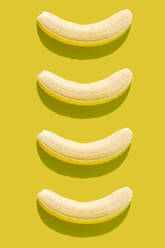 3D illustration of peeled bananas on yellow background - GEMF03596