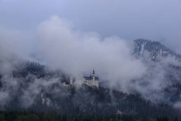 Germany, Bavaria, Hohenschwangau, Aerial view of Neuschwanstein Castle shrouded in fog - LBF03035