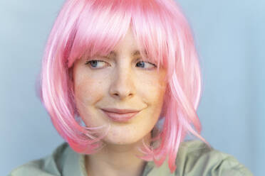 Porträt einer jungen Frau mit rosa Perücke, die zur Seite blickt - AFVF06090