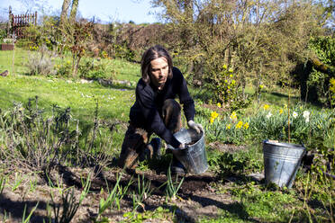 Mann bei der Arbeit im Bio-Garten im Frühling - NDF01049