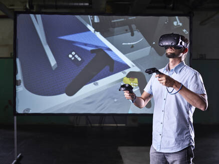 Mann trägt VR-Brille und benutzt Joysticks in virtuellem Trainingskurs - CVF01576