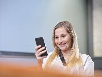 Portrait of smiling businesswoman using cell phone - CVF01586