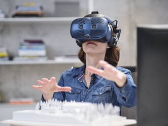 Frau mit VR-Brille und Headset in einem modernen Büro - CVF01595