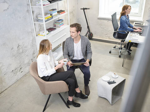 Businessman and businesswoman with tablet having a meeting in modern office stock photo