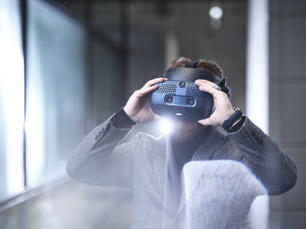 Mann mit VR-Brille und Headset in einem modernen Büro - CVF01619