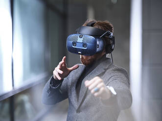 Mann mit VR-Brille und Headset in einem modernen Büro - CVF01620