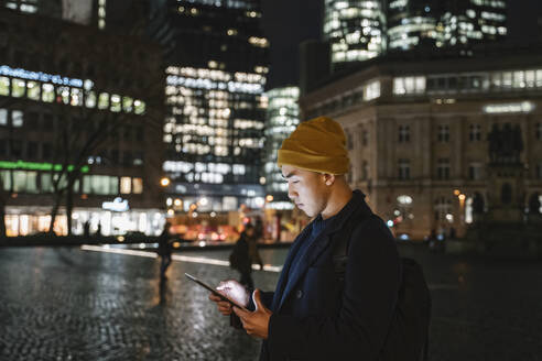 Mann benutzt Tablet in der Stadt bei Nacht - AHSF02293