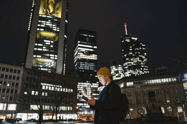 Mann benutzt Tablet in der Stadt bei Nacht - AHSF02294