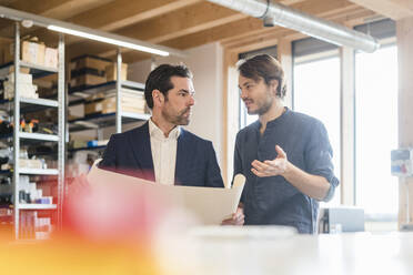 Businessman and employee discussing plan in factory - DIGF09853