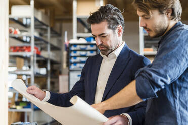 Businessman and employee discussing plan in factory - DIGF09854