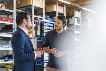 Businessman and employee talking in factory - DIGF09868