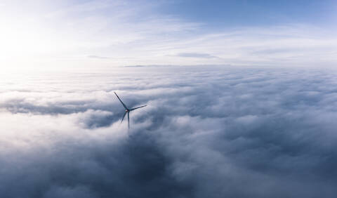 Germany, Aerial view of wind turbine shrouded in clouds at dawn stock photo