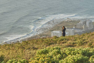 Woman taking pictures from the top of a hill, Signal Hill, South Africa - VEGF01896