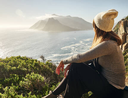 Woman enjoying the view from the top of a mountain, Chapman's Peak Drive, South Africa - VEGF01907