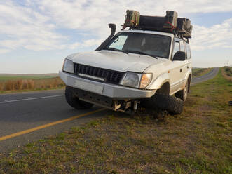 Off-road vehicle with flat tyre at, the side of the road. South Africa - VEGF01914