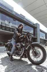 Porträt einer selbstbewussten jungen Frau auf einem Motorrad - DAMF00372