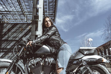 Selbstbewusste junge Frau auf Motorrad - DAMF00373