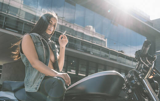 Porträt einer sexy jungen Frau auf einem Motorrad - DAMF00375