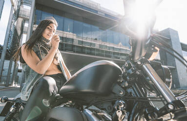 Porträt einer sexy jungen Frau auf einem Motorrad - DAMF00376