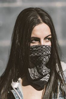 Porträt einer schönen jungen Frau, die ein Halstuch als Maske trägt - DAMF00378