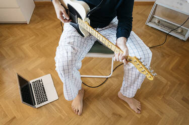 Crop-Ansicht eines Mannes, der zu Hause E-Gitarre spielt - JCMF00581
