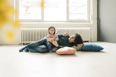 Mother relaxing with daughter on the floor - JOSEF00285