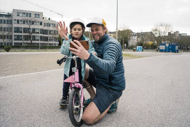 Glücklicher Vater und Tochter mit Fahrrad machen ein Selfie - JOSEF00288