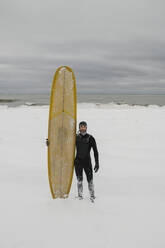 Surfer mit Surfbrett im Schnee in Ontario, Kanada - HWHF00004