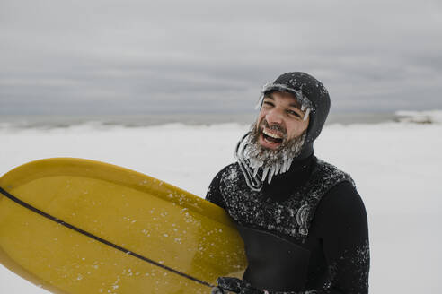 Surfer mit Surfbrett im Schnee in Ontario, Kanada - HWHF00005