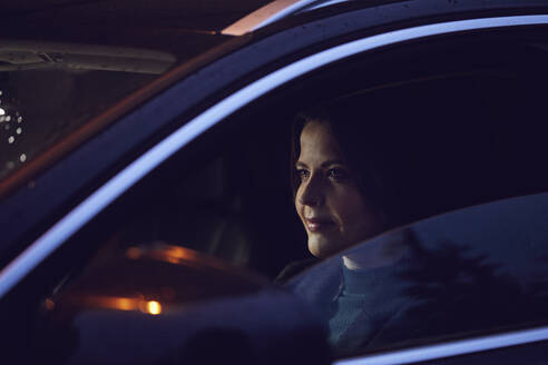 Portrait of confident woman in car at night - MCF00730