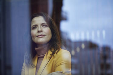 Porträt einer selbstbewussten Geschäftsfrau, die aus dem Fenster schaut - MCF00765
