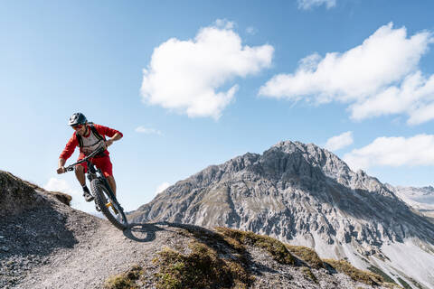 Mann fährt mit dem Mountainbike, Münstertal, Graubünden, Schweiz, lizenzfreies Stockfoto