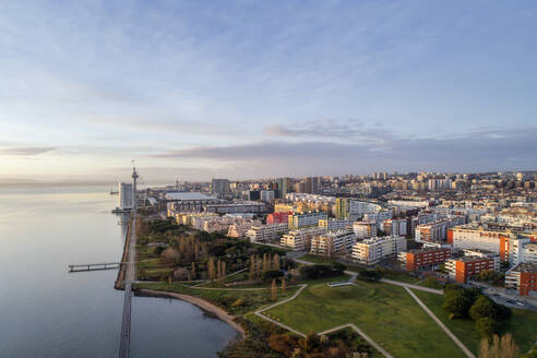Portugal, Lisbon, Drone view of residential district of coastal city at dusk - RPSF00286