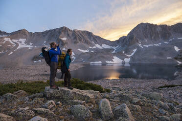 Wandererinnen beobachten den Sonnenuntergang von den Pierre Lakes, Elk Mountains, Colorado - CAVF79082