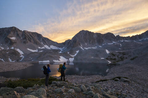 Women hikers watch sunset from Pierre Lakes, Elk Mountains, Colorado stock photo