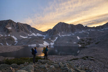 Wandererinnen beobachten den Sonnenuntergang von den Pierre Lakes, Elk Mountains, Colorado - CAVF79083