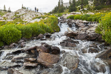 Wanderer passieren einen Wasserfall in der Nähe der Pierre Lakes, Elk Mountains, Colorado - CAVF79084