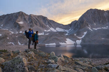 Women hikers watch sunset from Pierre Lakes, Elk Mountains, Colorado - CAVF79086