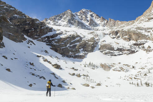 Frau wandert über den zugefrorenen Black Lake, Rocky Mountain National Park - CAVF79096