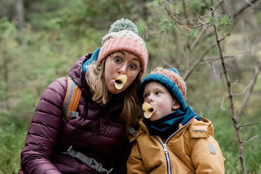 Mutter und Sohn machen beim Winterwandern dumme Gesichter mit Essen - CAVF79222