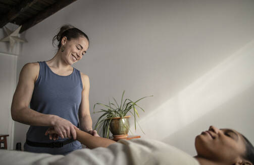 A female massage therapist works on an african american female client - CAVF79235