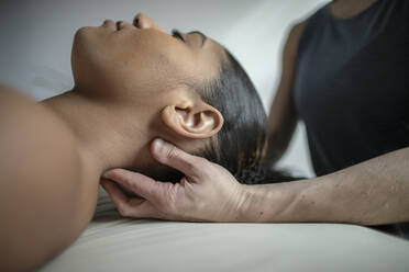 Nahaufnahme einer afroamerikanischen Frau, die eine Nackenmassage erhält - CAVF79236