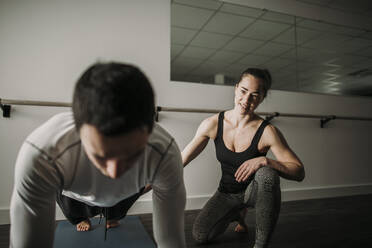 Female personal trainer coaches male client doing push ups - CAVF79254