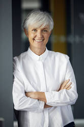 Portrait of smiling senior businesswoman with arms crossed - RBF07577